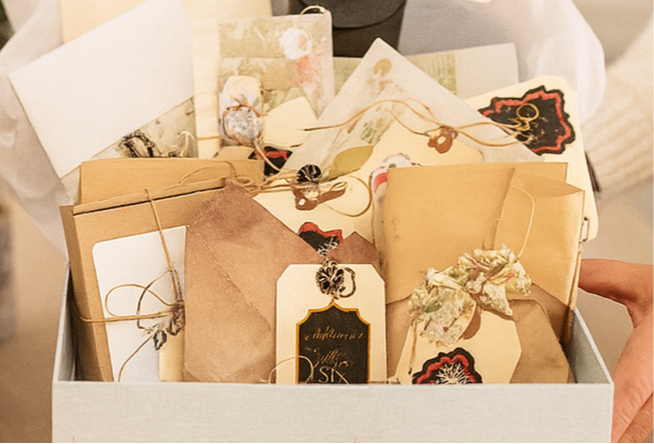 Decorative box filled with stationery items on a neutral background