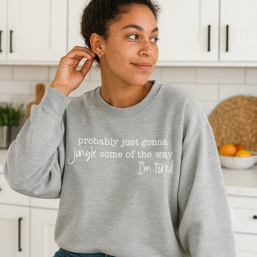 Woman wearing a gray sweatshirt with text in a kitchen setting